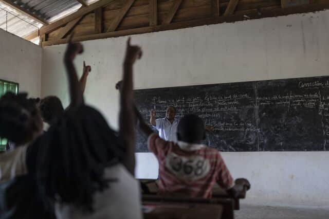 Pupils rise their hands to answer a question at the local school at Nyanga ranch, on October 10, 2022.