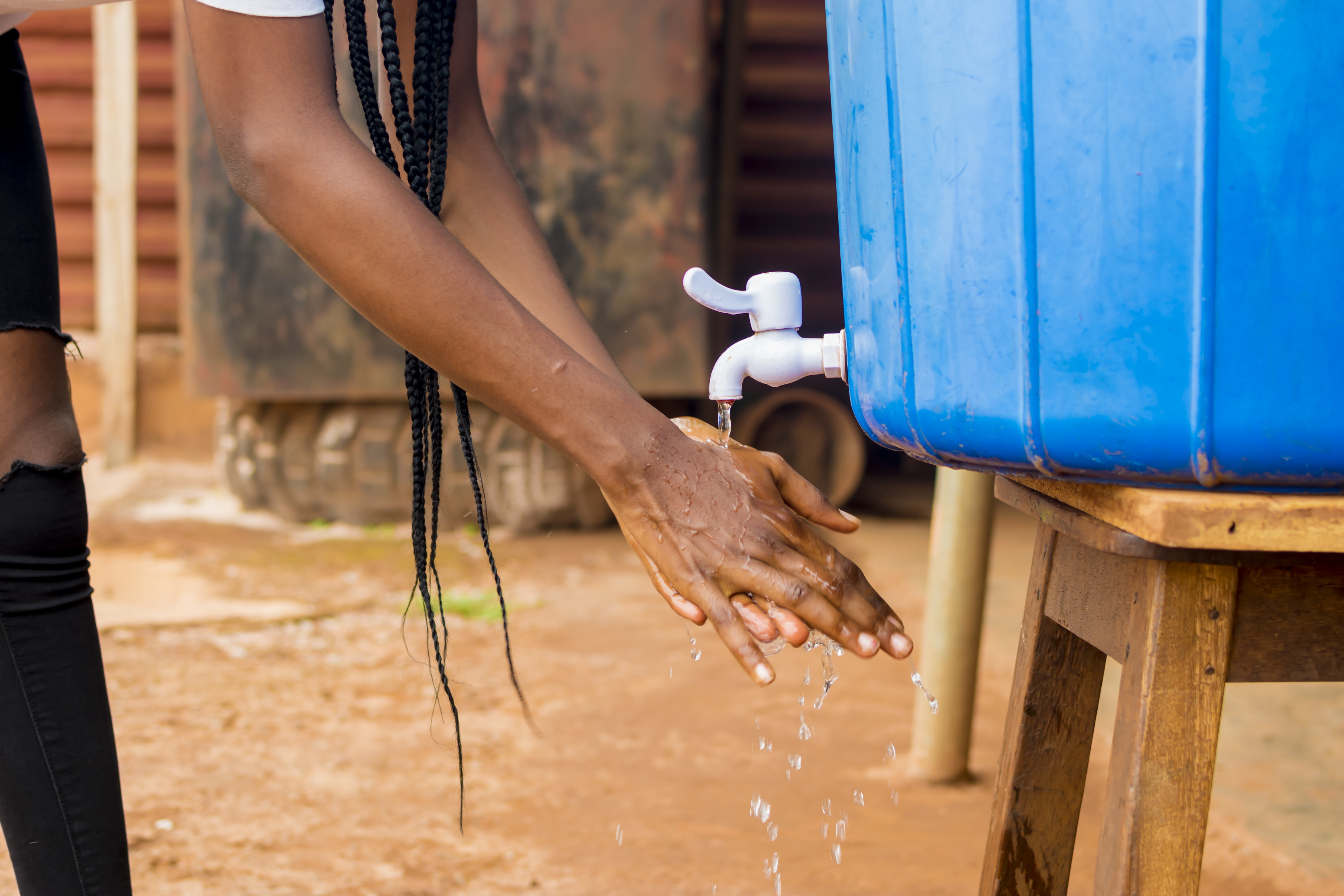 Person washing their hands at an outdoor water station